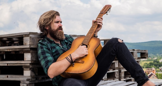 Just relax casual male guitarist concept of music and vocal man playing the acoustic guitar brutal man with moustache and beard hold guitar music shop bearded man being a rock star