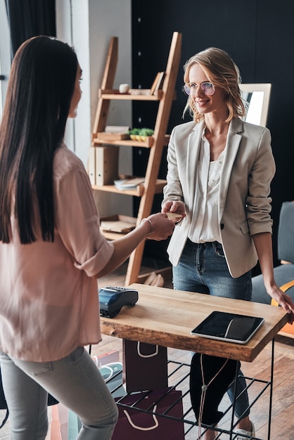 just shopping. beautiful young woman giving a credit card to salesperson 