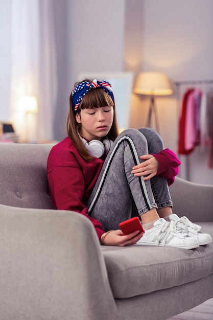 Aspetta. ragazza attenta guardando il suo gadget e in attesa di messaggio