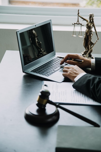 Justice and Law concept Legal counsel presents to the client a signed contract with gavel and legal law or legal having team meeting at law firm in background