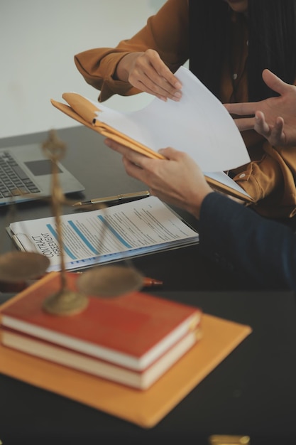 Foto concetto di giustizia e legge il consulente legale presenta al cliente un contratto firmato con un martello e una riunione di squadra legale o legale nello studio legale in sottofondo