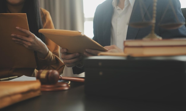 Photo justice and law concept legal counsel presents to the client a signed contract with gavel and legal law or legal having team meeting at law firm in background