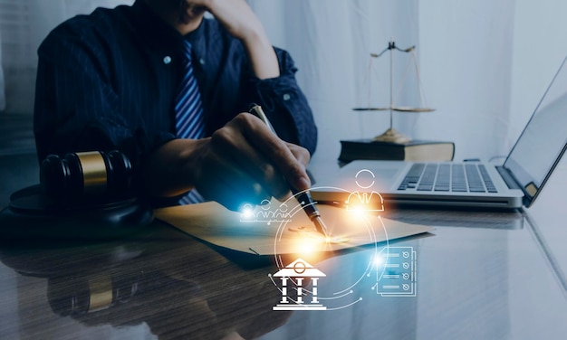 Justice and law conceptMale judge in a courtroom with the gavel working with computer and docking keyboard eyeglasses on table in morning light