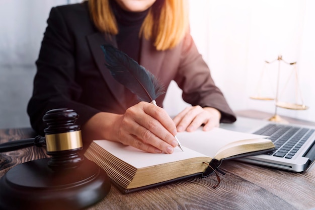 Justice and law conceptMale judge in a courtroom with the gavel working with computer and docking keyboard eyeglasses on table in morning light