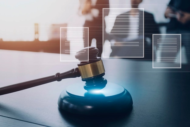 Justice and law conceptMale judge in a courtroom with the gavel working with computer and docking keyboard eyeglasses on table in morning light