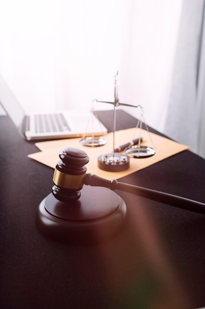 Justice and law conceptMale judge in a courtroom with the gavel working with computer and docking keyboard eyeglasses on table in morning light