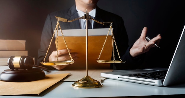 Justice and law conceptMale judge in a courtroom with the gavel working with computer and docking keyboard eyeglasses on table in morning light