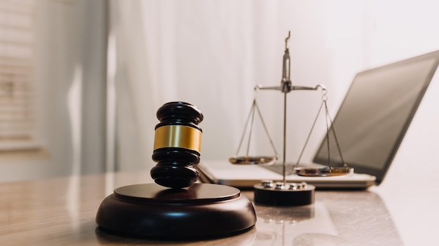 Justice and law conceptMale judge in a courtroom with the gavel working with computer and docking keyboard eyeglasses on table in morning light