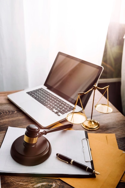 Justice and law conceptMale judge in a courtroom with the gavel working with computer and docking keyboard eyeglasses on table in morning light