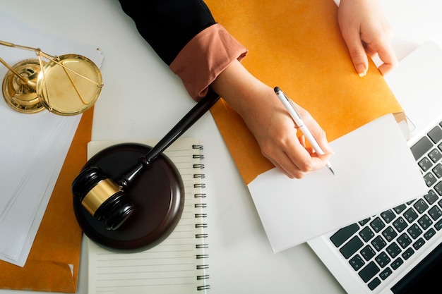 Justice and law conceptMale judge in a courtroom with the gavel working with computer and docking keyboard eyeglasses on table in morning light