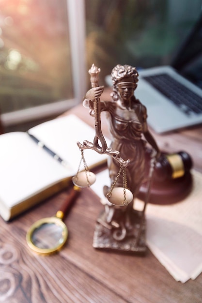 Justice and law conceptMale judge in a courtroom with the gavel working with computer and docking keyboard eyeglasses on table in morning light