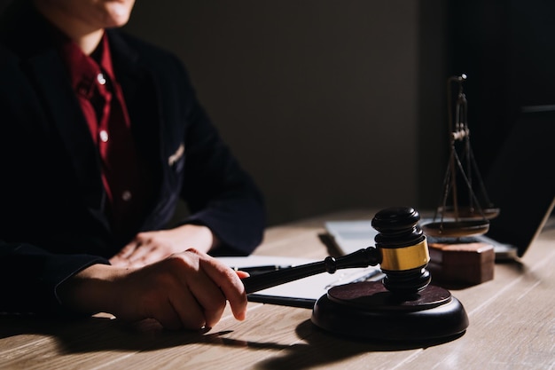 Justice and law conceptMale judge in a courtroom with the gavel working with computer and docking keyboard eyeglasses on table in morning light