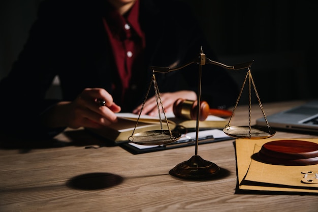 Justice and law conceptMale judge in a courtroom with the gavel working with computer and docking keyboard eyeglasses on table in morning light