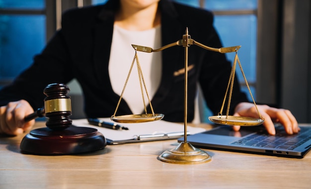 Justice and law conceptMale judge in a courtroom with the gavel working with computer and docking keyboard eyeglasses on table in morning light