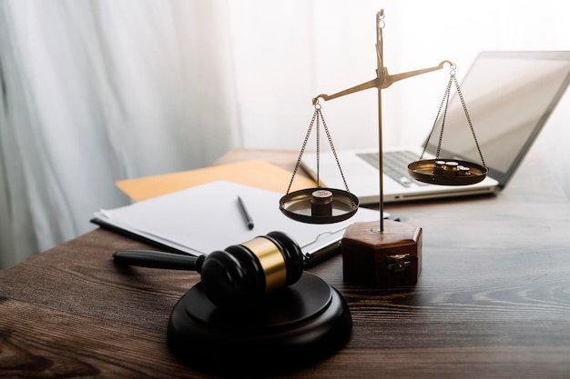 Justice and law conceptMale judge in a courtroom with the gavel working with computer and docking keyboard eyeglasses on table in morning light