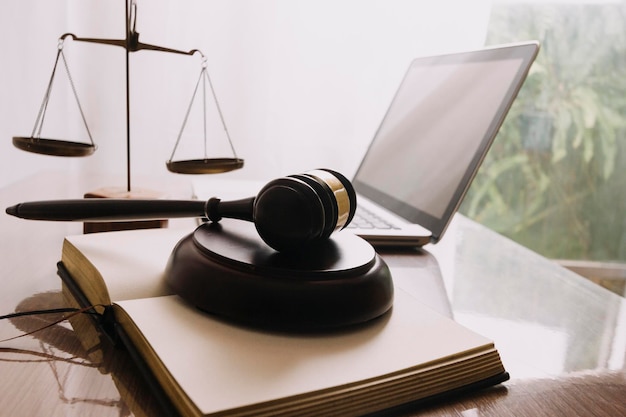 Justice and law conceptMale judge in a courtroom with the gavel working with computer and docking keyboard eyeglasses on table in morning light