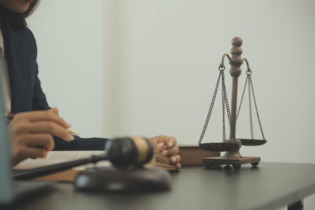 Justice and law conceptMale judge in a courtroom with the gavel working with computer and docking keyboard eyeglasses on table in morning light