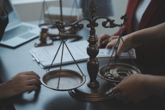 Justice and law conceptMale judge in a courtroom with the gavel working with computer and docking keyboard eyeglasses on table in morning light