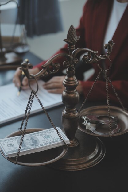 Justice and law conceptMale judge in a courtroom with the gavel working with computer and docking keyboard eyeglasses on table in morning light