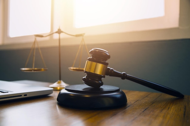 Justice and law conceptMale judge in a courtroom with the gavel working with computer and docking keyboard eyeglasses on table in morning light