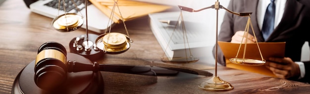 Justice and law conceptMale judge in a courtroom with the gavel working with computer and docking keyboard eyeglasses on table in morning light