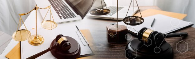 Justice and law conceptMale judge in a courtroom with the gavel working with computer and docking keyboard eyeglasses on table in morning light