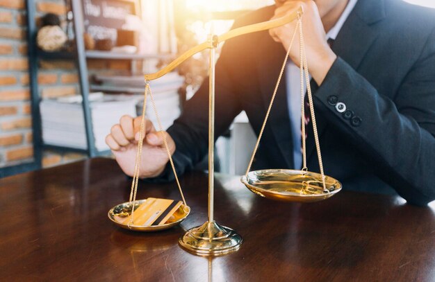 Justice and law conceptMale judge in a courtroom with the gavel working with computer and docking keyboard eyeglasses on table in morning light