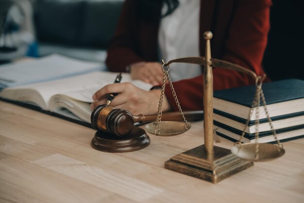 Justice and law conceptMale judge in a courtroom with the gavel working with computer and docking keyboard eyeglasses on table in morning light