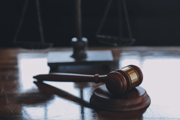 Justice and law conceptMale judge in a courtroom with the gavel working with computer and docking keyboard eyeglasses on table in morning light