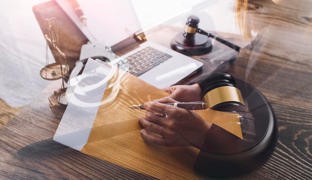 Justice and law conceptMale judge in a courtroom with the gavel working with computer and docking keyboard eyeglasses on table in morning light