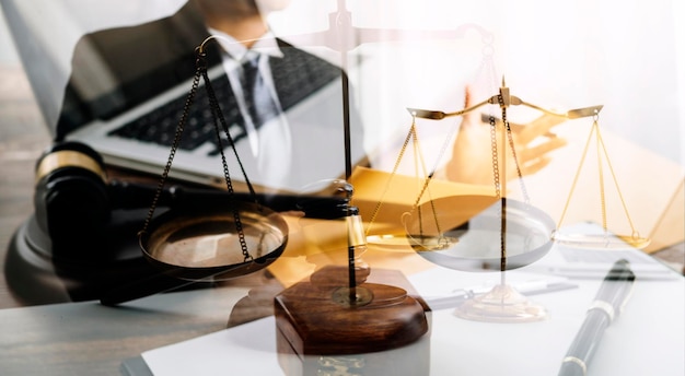 Justice and law conceptMale judge in a courtroom with the gavel working with computer and docking keyboard eyeglasses on table in morning light