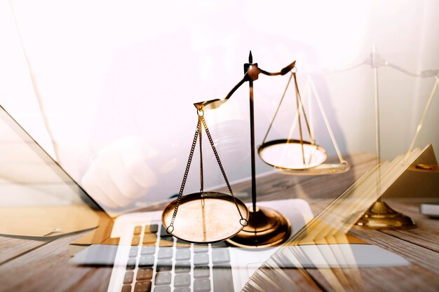 Justice and law conceptMale judge in a courtroom with the gavel working with computer and docking keyboard eyeglasses on table in morning light