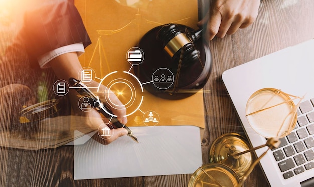 Justice and law conceptMale judge in a courtroom with the gavel working with computer and docking keyboard eyeglasses on table in morning light