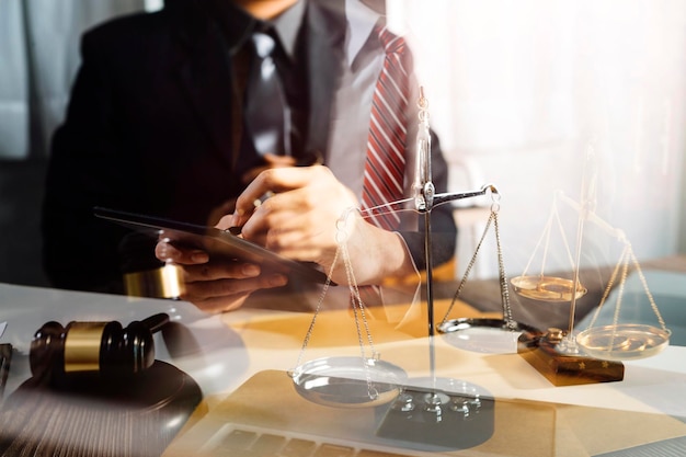 Justice and law conceptMale judge in a courtroom with the gavel working with computer and docking keyboard eyeglasses on table in morning light