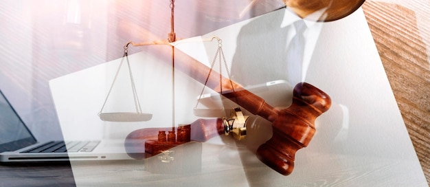 Justice and law conceptMale judge in a courtroom with the gavel working with computer and docking keyboard eyeglasses on table in morning light