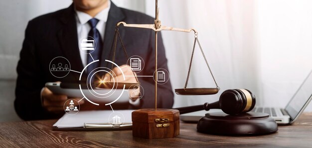 Justice and law conceptMale judge in a courtroom with the gavel working with computer and docking keyboard eyeglasses on table in morning light