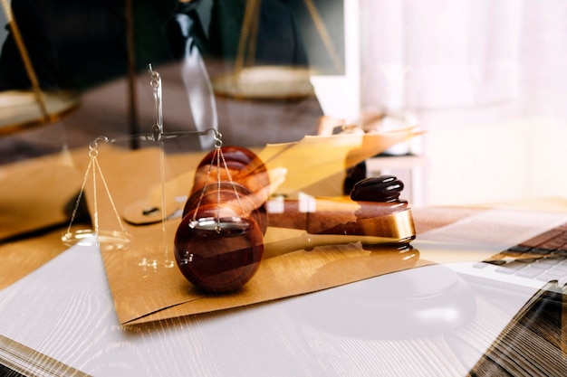 Justice and law conceptMale judge in a courtroom with the gavel working with computer and docking keyboard eyeglasses on table in morning light