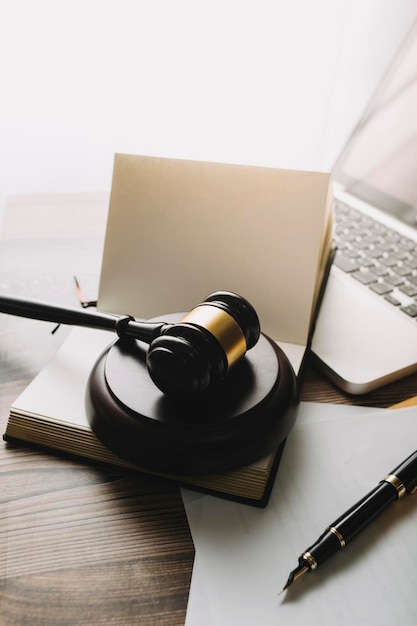 Justice and law conceptMale judge in a courtroom with the gavel working with computer and docking keyboard eyeglasses on table in morning light