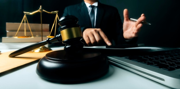 Justice and law conceptMale judge in a courtroom with the gavel working with computer and docking keyboard eyeglasses on table in morning light