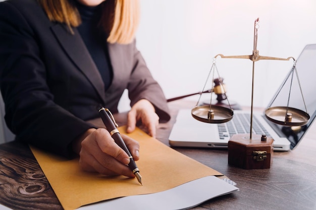 Justice and law conceptMale judge in a courtroom with the gavel working with computer and docking keyboard eyeglasses on table in morning light