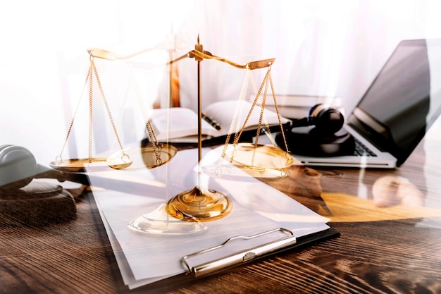 Justice and law conceptMale judge in a courtroom with the gavel working with computer and docking keyboard eyeglasses on table in morning light