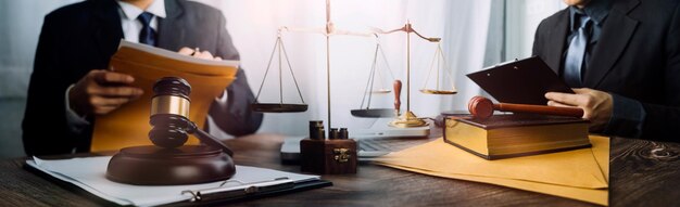 Концепция правосудия и праваСудья-мужчина в зале суда на деревянном столе и советник или юрист-мужчина, работающий в офисе Юридические консультации и концепция правосудия