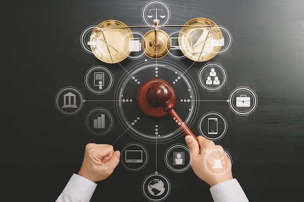 Justice and law conceptT op view of Male judge hand in a courtroom with the gavel and brass scale