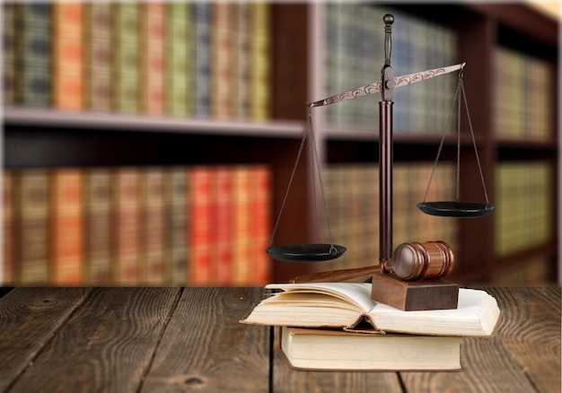 Justice Scales and books and gavel on blurred background