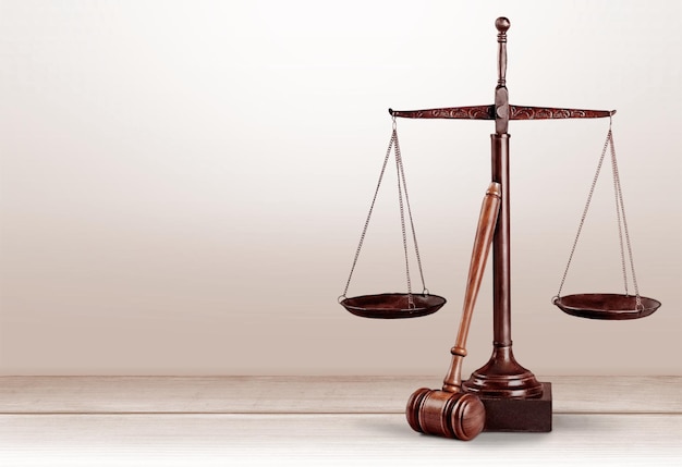 Весы правосудия и деревянный молоток на деревянном столе