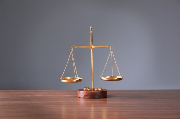 Justice scales on wooden table and  grey