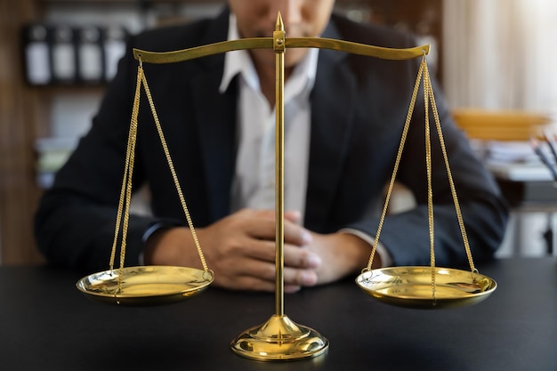 Justitie en recht concept Close-up gouden schalen met wazige advocaat als achtergrond