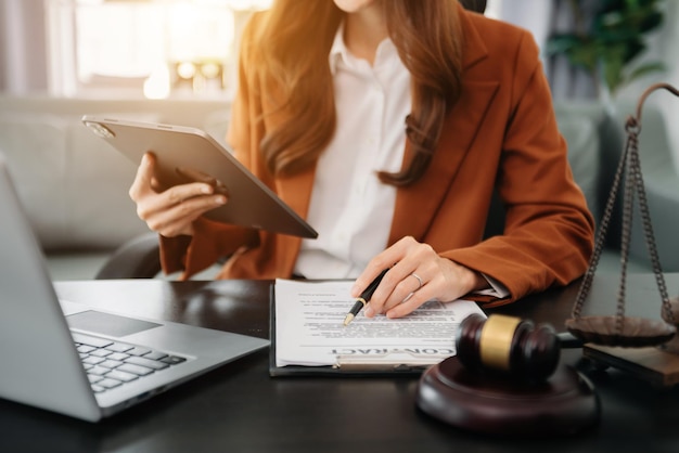 Justitie en recht concept Mannelijke rechter in een rechtszaal de hamer werken met slimme telefoon en laptop en digitale tabletcomputer op houten tafel in ochtendlicht xA