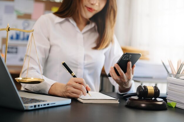 Justitie en recht concept Mannelijke rechter in een rechtszaal de hamer werken met slimme telefoon en laptop en digitale tabletcomputer op houten tafel in ochtendlicht xA