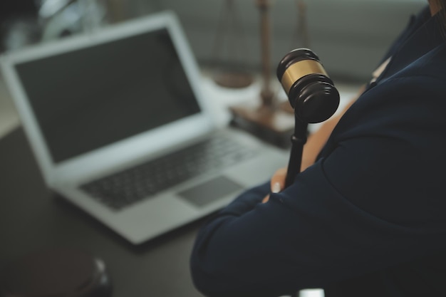 Justitie en recht concept Mannelijke rechter in een rechtszaal met de hamer werken met computer en toetsenbord bril op tafel in ochtendlicht docking